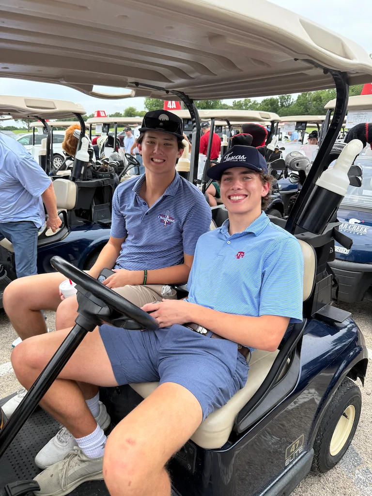 Two alumni riding in a golf cart during Reunion Weekend