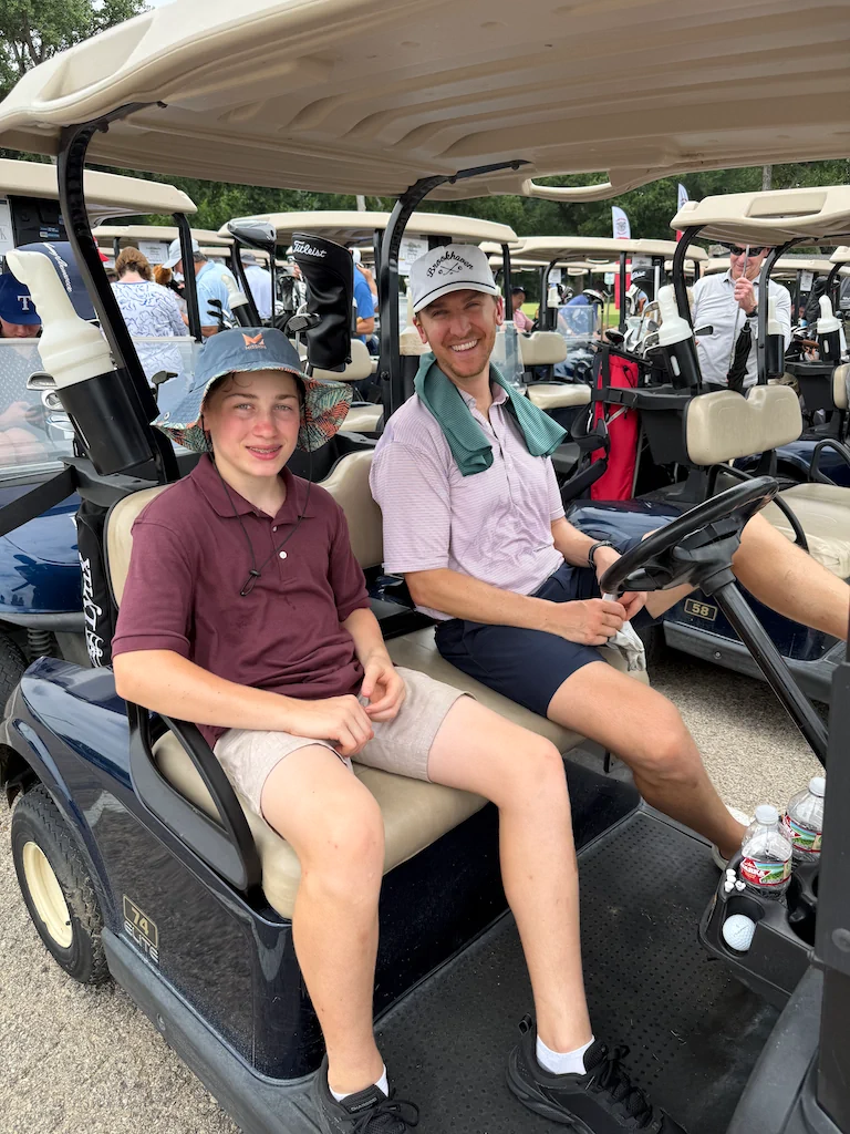 Golf outing participants riding in a golf cart