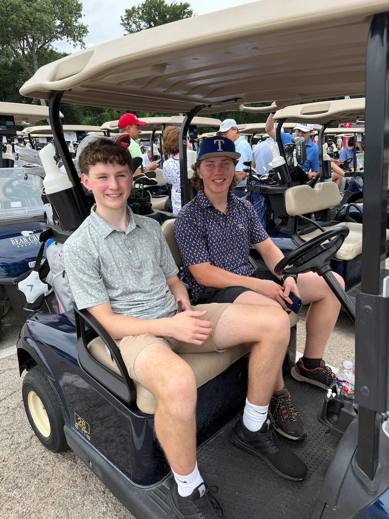 Two alumni traveling between holes during the golf outing