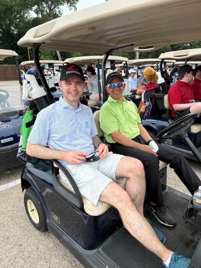 Alumni riders posing in a golf cart during Reunion Weekend