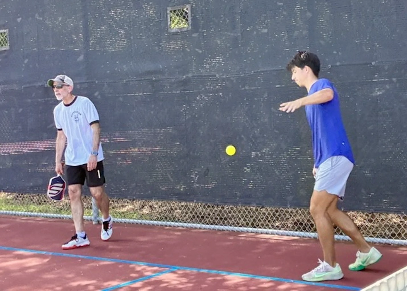 Pickleball match with player in blue shirt