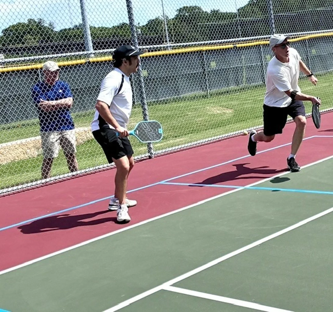 Pickleball players running on the court