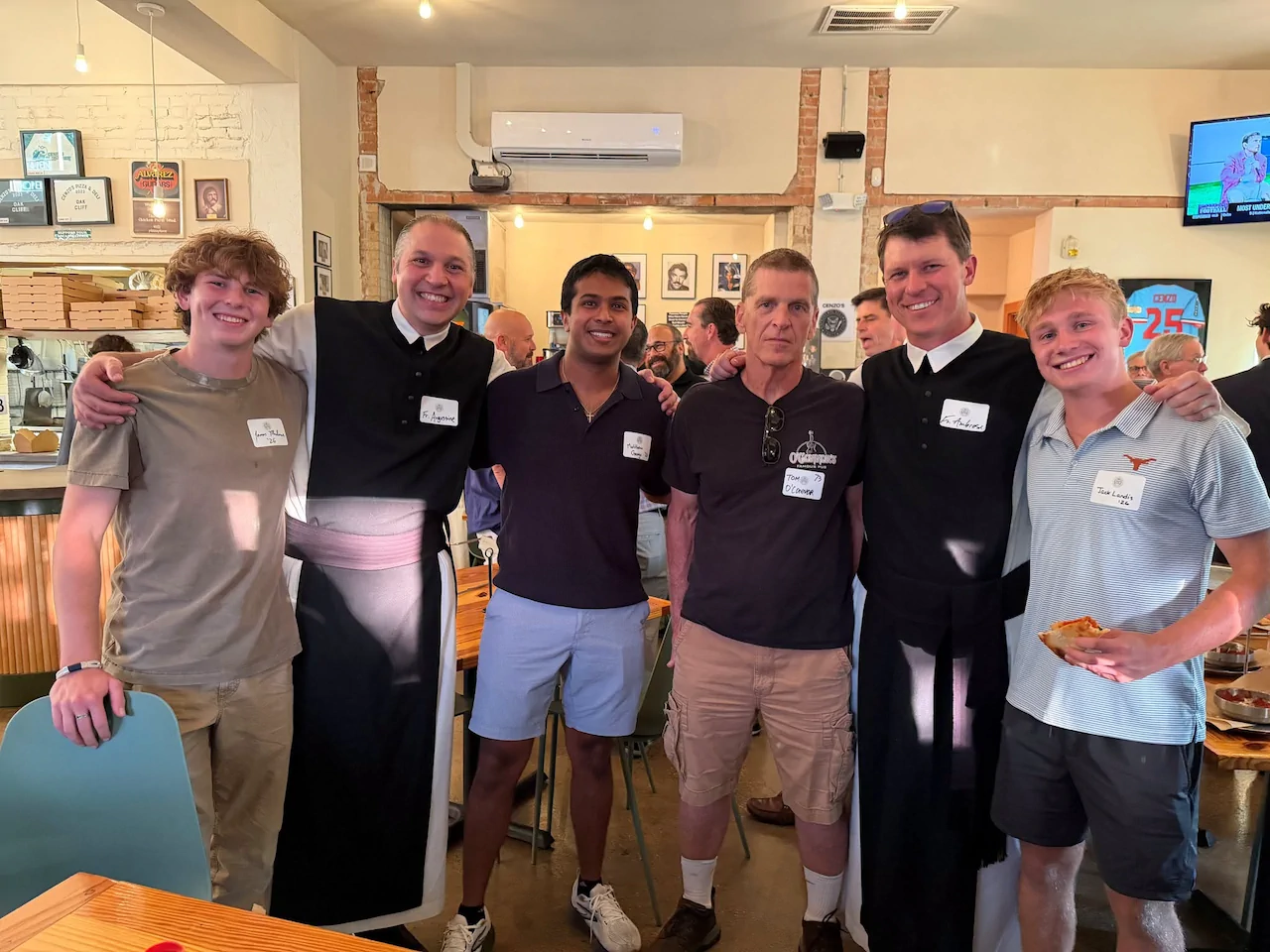 Cistercian alumni, Fr. Augustine, and Fr. Ambrose posing together during the Class Agent and Alumni Board Gathering at Cenzo’s Pizza & Deli.