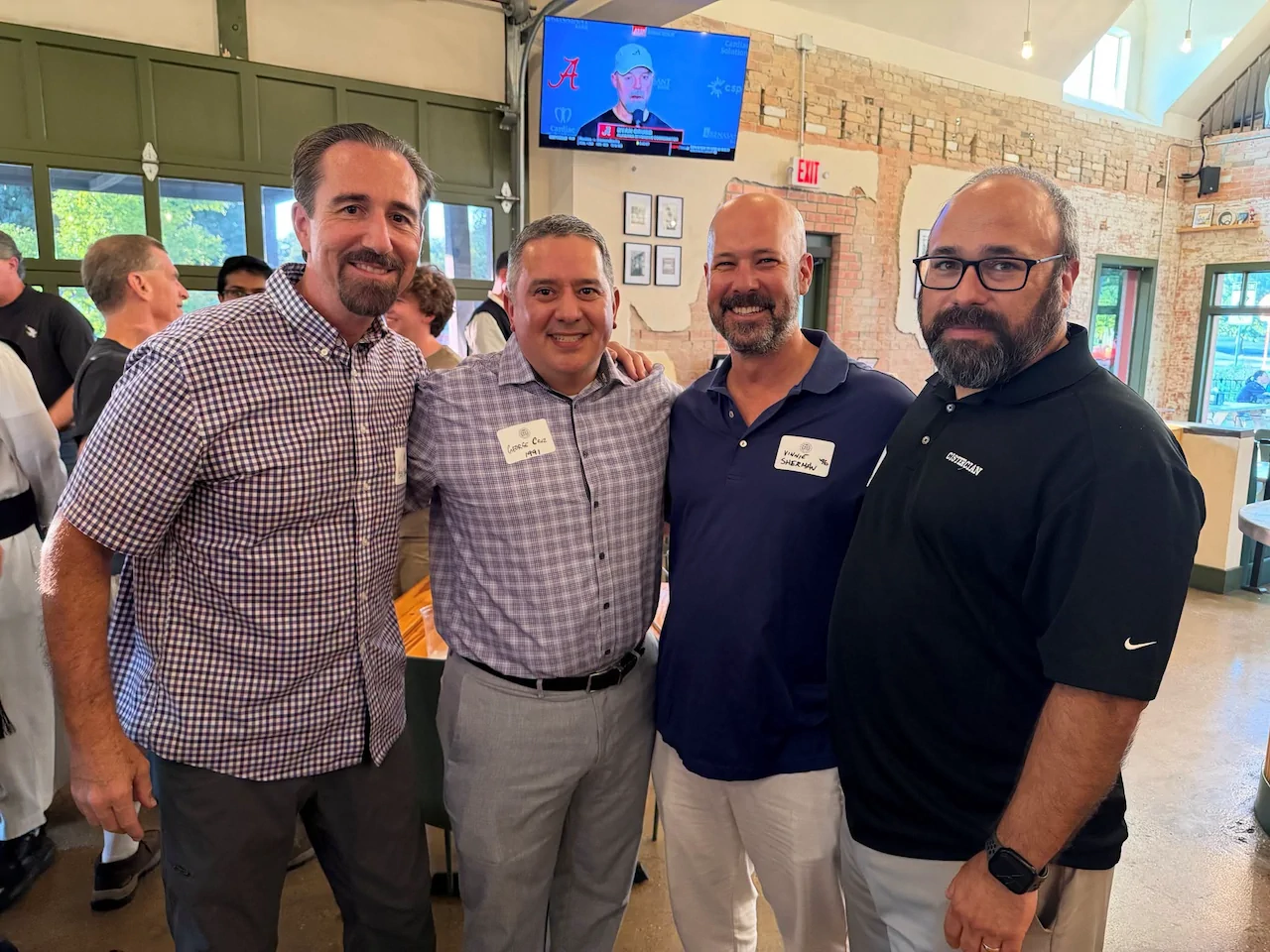 Four Cistercian alumni posing together during the annual alumni gathering at Cenzo’s Pizza & Deli.